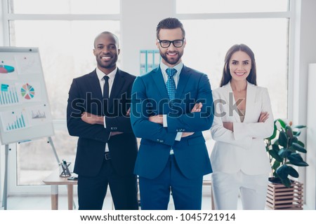 Stylish modern joyful cheerful business trio sharks in formalwear with tie, having arms crossed, standing in work place, station, looking at camera, men with bristle and glasses and beautiful woman Royalty-Free Stock Photo #1045721914