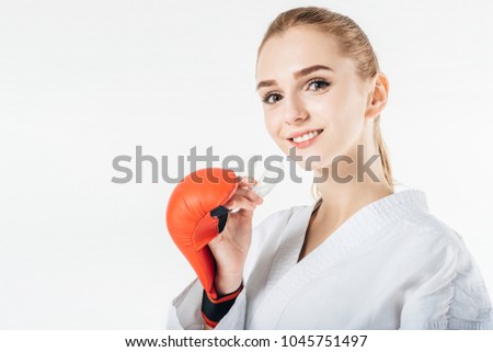 smiling female karate fighter holding mouthguard isolated on white Royalty-Free Stock Photo #1045751497