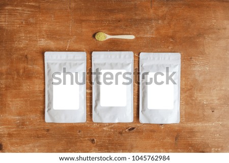 Three Blank Plastic Packaging Bags  with Isolated White Stickers Mock Up on Wooden Table