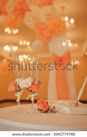 Wedding ceremony, table with rings. Details of wedding decorations. Rings, glasses, champagne, gift box. Orange color