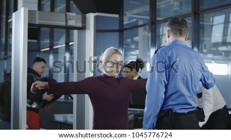 People going through procedure of physical inspection and luggage scanning in airport. Royalty-Free Stock Photo #1045776724