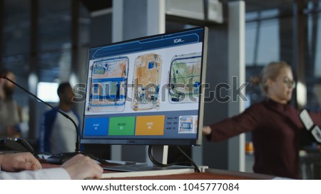 Anonymous man at checkpoint in airport exploring luggage on screen with x-ray. Royalty-Free Stock Photo #1045777084