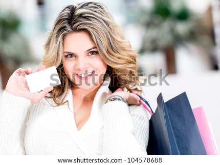Shopping woman holding a white contact card and smiling