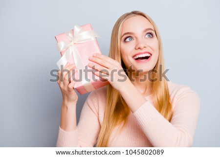 Chill rest relax joy fun funky enjoy rejoice concept. Close up portrait of cute lovely sweet pretty gentle toothy smile blonde-haired teen age girl holding giftbox near ear isolated on gray background