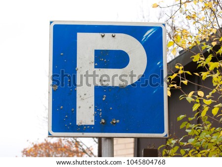 Parking sign in the park on sky background