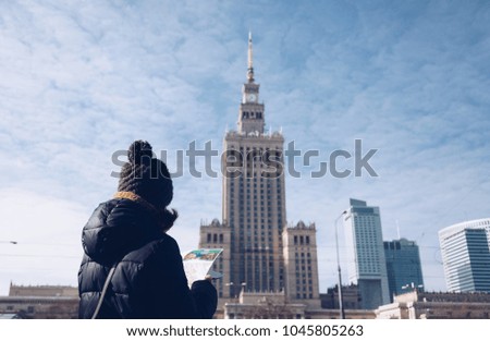 Young tourist with map against the Palace of Culture and Science - Warsaw.