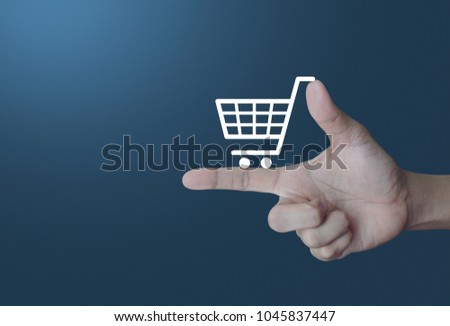 Shopping cart icon on finger over light gradient blue background, Shop online concept