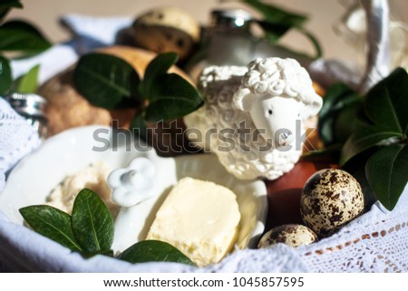 Stylish easter basket with food. horseradish, butter, ham, bread, buxus, sausage, muffin, painted eggs and Sugar Polish Easter Lamb in wicker basket. happy easter. Space for text