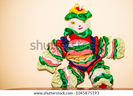Small clovne doll inside on yellow background , colorful toy