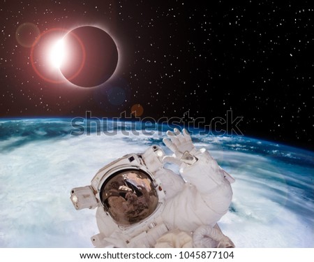 Solar eclipse seen above the earth. Astrounaut is near in space. The elements of this image furnished by NASA.