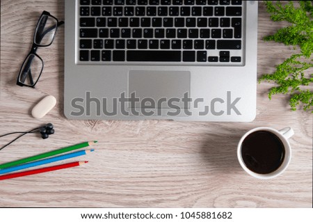 Notebook with hot coffee and flash-payer with headphones on wood table. Home business workplace concept