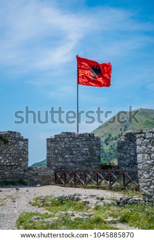 Albanian red flag with a black double-headed eagle towers above the fortress of Rozafa.
