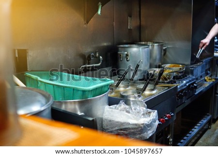 photo of open kitchen chef cooking food with hot boiler and metal stainless pot pan tools with gradient light