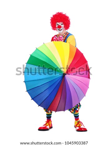 Happy clown behind opened umbrella against white background