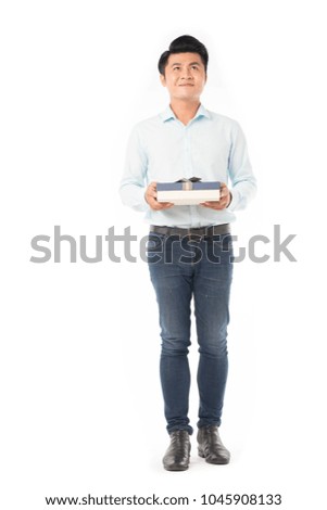 Studio portrait of young Asian man holding gift box