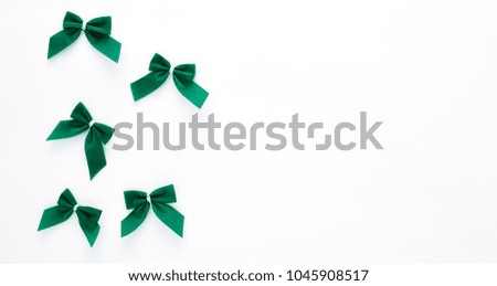 St Patricks Day side border of green bows over a white background
