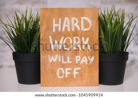 Wooden board with motivational text hard work will pay off