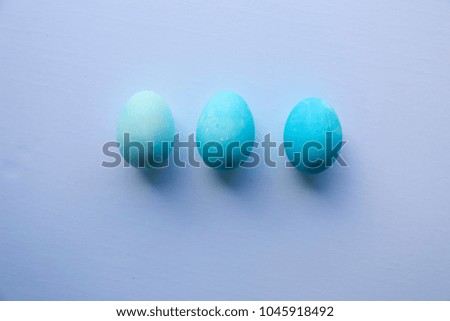 3 painted easter eggs in a row dyed in gradient shades of blue as a DIY family kids arts and crafts for the holidays