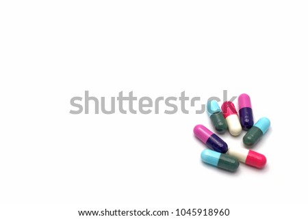 Pile of antibiotic capsules pills isolated on corner of white background with copy space for text. Medicine use in infectious disease concept.