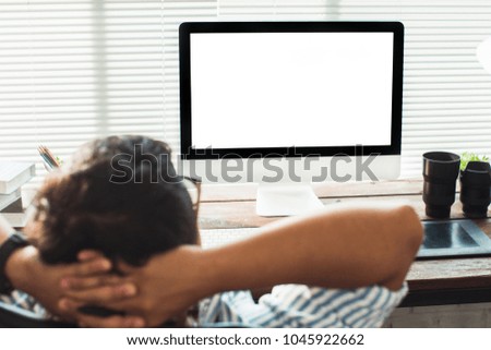 The photographer is retouching photos in the studio, he is relaxing from work.Computer with blank screen on table