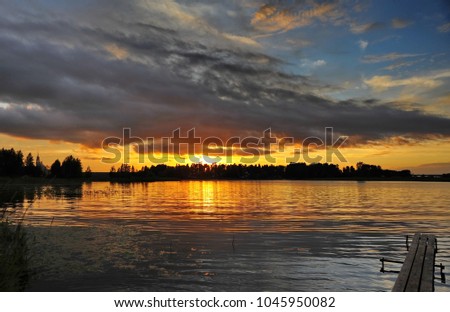 The picture was taken in the forest in July 2012 .The picture shows a sunset on a Pleshcheyevo lake.Reflection of clouds on the water, bridge on the lake.