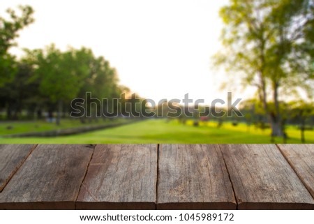 empty old wood table top on blur background tree in the green park Abstract Natural