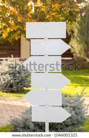 Park Sign Post Directions. White signposts sign in the park. White  wooden direction sign