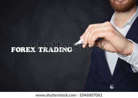 The businessman writes an inscription with a white marker:FOREX TRADING