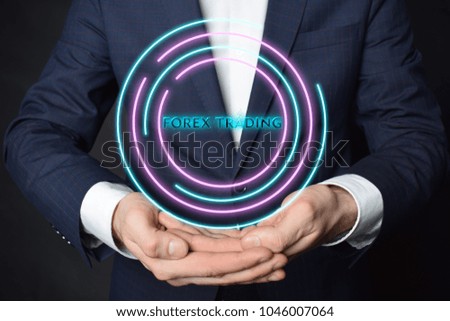 In the hands of a businessman, a neon circle with the inscription:FOREX TRADING