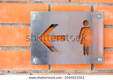 sign women arrow with orange wall block   