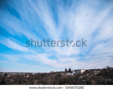 Clouds in the blue sky over a small village.