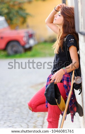 Portrait of cute urban girl with skateboard outdoors