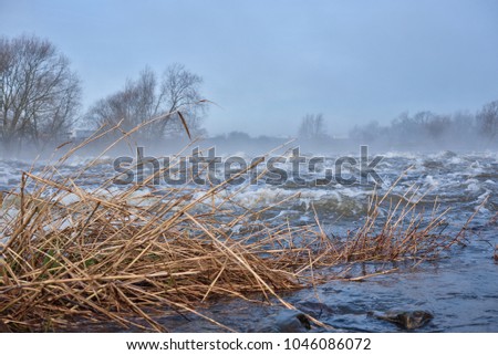 Low down view of a fast flowing misty river