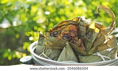 Zongzi or rice dumpling on bokeh light background for Dragon Boat Festival. Zongzi is basically glutinous rice with sweet or savoury fillings wrapped in bamboo or reed leaves. Popular Asian food.