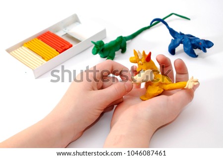 The child molds from plasticine animals.