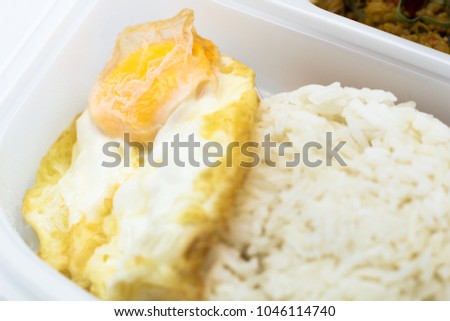Cost-up Thai food menu is Stir Fried Minced Chicken Breast with Hot Yellow Curry Paste Served with Rice and Fried Egg box set isolated on white background. It copy space and selection focus.