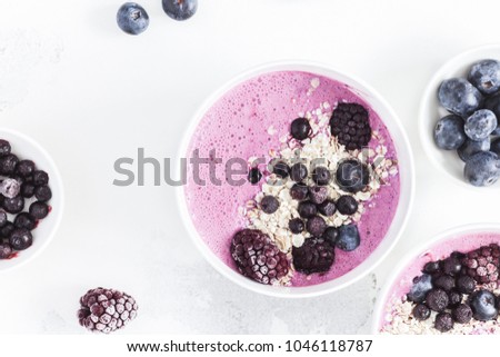 Breakfast with muesli, acai blueberry smoothie, fruits on white background. Healthy food concept. Flat lay, top view, close up