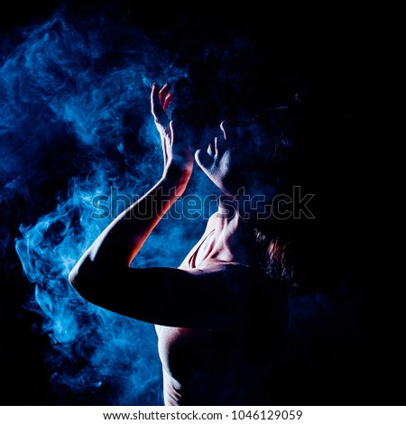 Modern teen contemporary dancer poses in front of the studio background. Toned image. Like a doll view. smoke portrait view with copyspace close