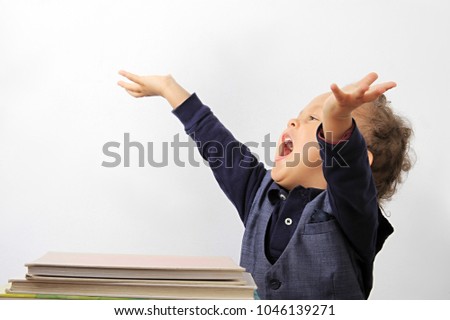little boy with books at school and arms outstretched stock photo