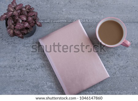 Pink journal on a desktop with a cup of coffee