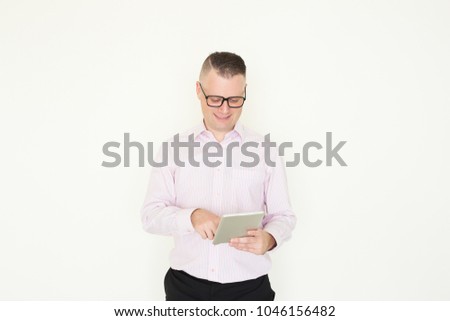 Smiling intelligent male manager analyzing report on tablet. Content confident businessman working with modern device. Mobility concept