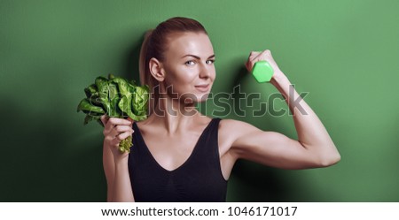 girl in sports top holds gattelu and bunches of spinach