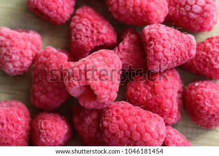 Frozen sweet eye raspberries on wooden background
