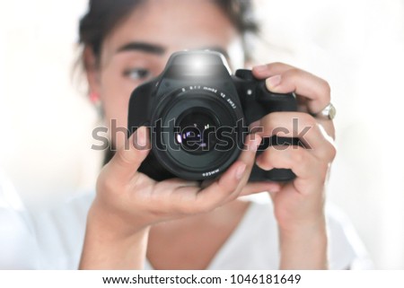 woman holding a photo camera and taking a picture with flash
