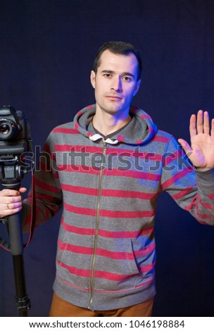 A guy with a camera on a monopod, 
video operator portrait