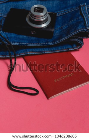 Passport, Clothes, Photo Camera on Pink Background. Travel Concept with Copyspace.