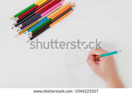 hand drawing with color double-sided pencils on white background, female hand drawing the house