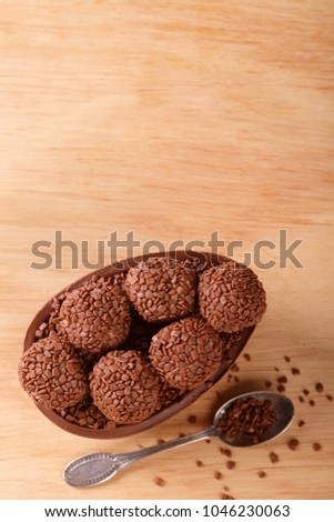 Chocolate egg with filling of brigadeiro for Easter on wooden background. Selective focus. Copy space