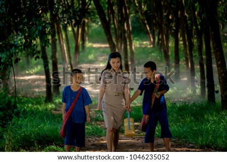 Two boy with teacher in rural areas are learn from nature outside the classroom. Learning and teaching students in rural areas of thailand. 
