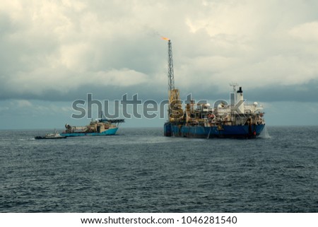 dynamic positioning DP operations near FPSO tanker. Supply fleet job, DSV diving support vessel is approaching. Crewboat is coming for crewchange. Oil and gas research and production industry. Royalty-Free Stock Photo #1046281540